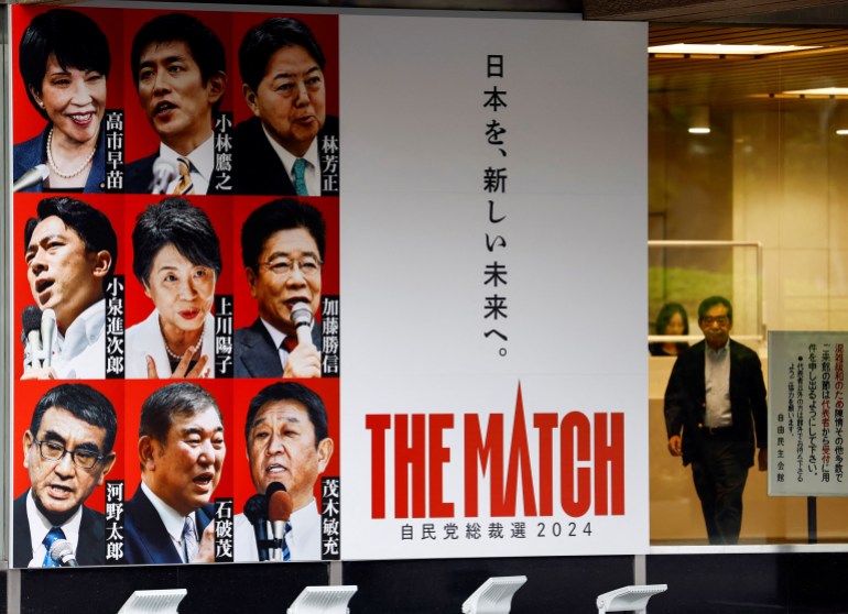 A giant poster with portraits of the candidates. It reads 'The Match' in English and Japanese. A man is walking next to it. 