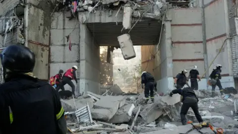 Eugene Hertnier/Suspilne Ukraine/JSC Rescue workers conduct search and rescue operation at a high-rise residential building partially destroyed by Russian shelling on September 24, 2024 in Kharkiv, Ukraine