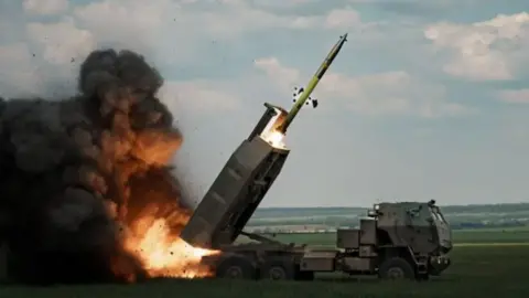 Getty Images An image of a High Mobility Artillery Rocket Systems (Himars) being fired with some countryside in the background