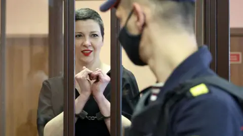 RAMIL NASIBULIN/BELTA/AFP Maria Kolesnikova, the last remaining protest leader still in Belarus, gestures making a heart shape inside the defendants' cage during her verdict hearing on charges of undermining national security, conspiring to seize power and creating an extremist group, on September 6, 2021 in Minsk.