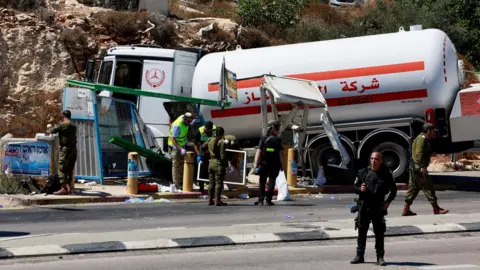 Reuters Israeli security and emergency personnel work at the scene of what the Israeli military said was a tanker ramming attack near the settler outpost of Givat Assaf, in the occupied West Bank (11 September 2024)