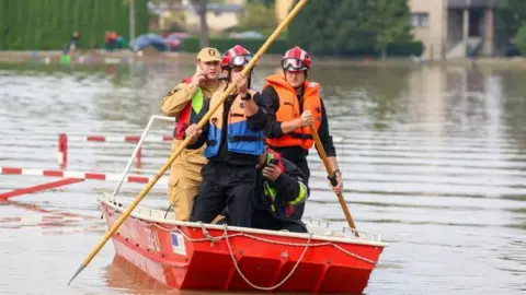 EPA Rescuers use poles to move a raft in a flooded areas of Czechowice-Dziedzice, south Poland