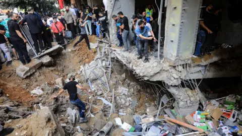 Getty Images People check the damage following an Israeli strike in Beirut's southern suburbs on September 20, 2024.