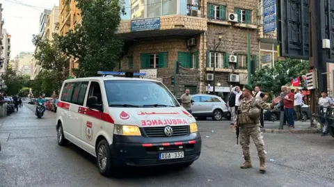 Getty Images An ambulance drives past a soldier in Lebanon after the attacks