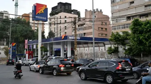 EPA Vehicles queue to get fuel at a gas station in Beirut