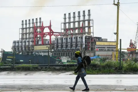 AFP A Cuban walks next to a floating power plant in Havana Harbour on October 21, 2024.