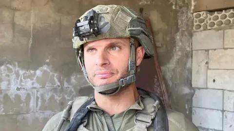 Col Yaniv Malka, who is leading troops into Lebanon, speaks to a camera in a combat zone in the country 