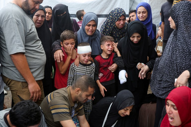 Children react next to the bodies of Palestinians, who were killed in Israeli strikes, amid the Israel-Hamas conflict, at Al-Aqsa Martyrs Hospital in Deir Al-Balah in the central Gaza Strip, October 8, 2024. REUTERS/Ramadan Abed TPX IMAGES OF THE DAY