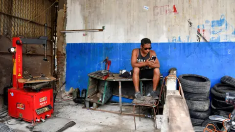 Reuters A man sits in a workshop as Cuba is hit by an island-wide blackout,