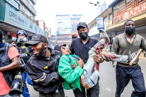 Getty Images Angry youthful protester help their fellow who was shot down during a demonstration over police killings of people protesting against Kenya's proposed finance bill in Nairobi  on 2 July 