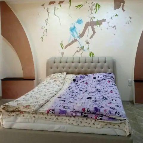 Marina Perederii Bedroom with cherry blossom and doves painted on the wall by the bed.