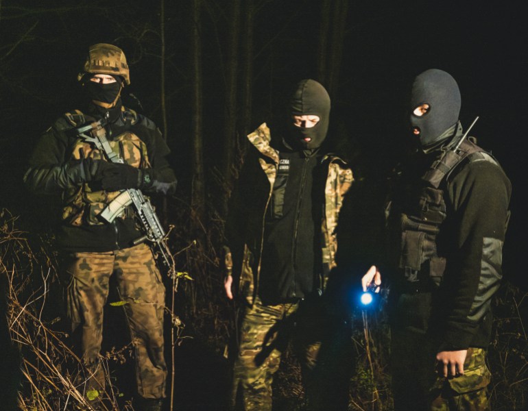 A photo of Polish border guards in the dark.