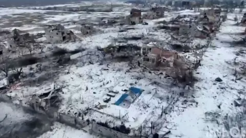 Donbass opeartivniy/Telegram Seen from the air, Marina's damaged house and empty blue swimming pool - there is snow on the ground and other damaged building nearby.