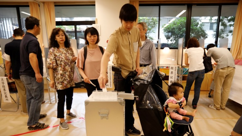 A voter casts a ballot at a voting station during Japan''s upper house election in Tokyo