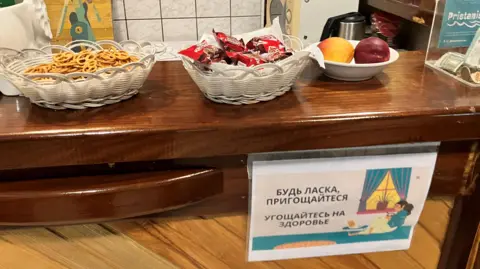 A sign in Ukrainian and Russian at Pristaniste's cafe invites residents to help themselves to snacks