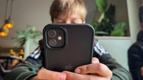 Getty Images A young boy looks at a smartphone 