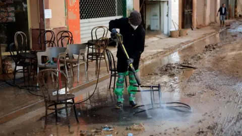 EPA-EFE/REX/Shutterstock The province of Valencia is still getting back on its feet after the floods. Here a volunteer cleans the chairs of a bar in Catarroja