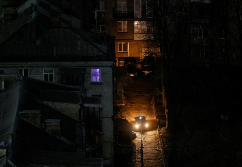 A car passes next to residential buildings during a power outage, amid Russia's attack on Ukraine, in Kyiv, Ukraine November 20, 2024. REUTERS/Gleb Garanich TPX IMAGES OF THE DAY