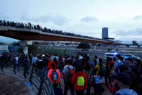 Reuters Columns of volunteers are seen marching to help with clean-up efforts after flooding in Valencia. 