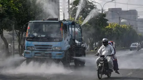 Getty Water is sprayed from a truck in Lahore 