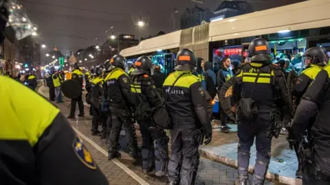 VLN Nieuws/ANP/AFP Dutch mobile police officers stand guard after several scuffles broke out in the city center following the UEFA Europa League match