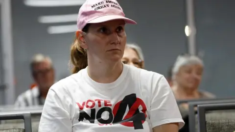 Reuters Ashley Urban, wearing a 'Vote No' on Florida Amendment 4 T-shirt, which addresses the state’s abortion bill, prays with other parishioners 