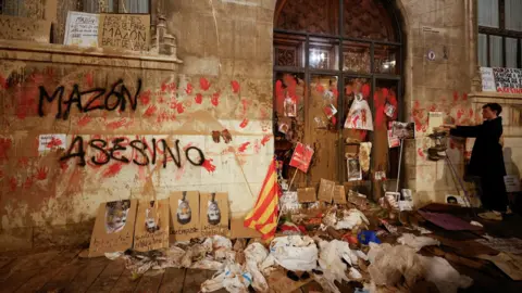 Reuters A person stands in front of Valencia's Regional Government Palace, which is stained with mud and paint, during a protest against Valencia's regional leader Carlos Mazon and the management of the emergency response to the deadly floods in eastern Spain, in Valencia, Spain,