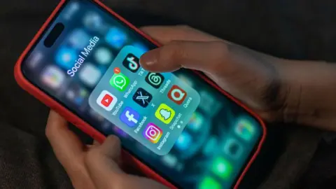 Getty Images A child holds a smartphone 