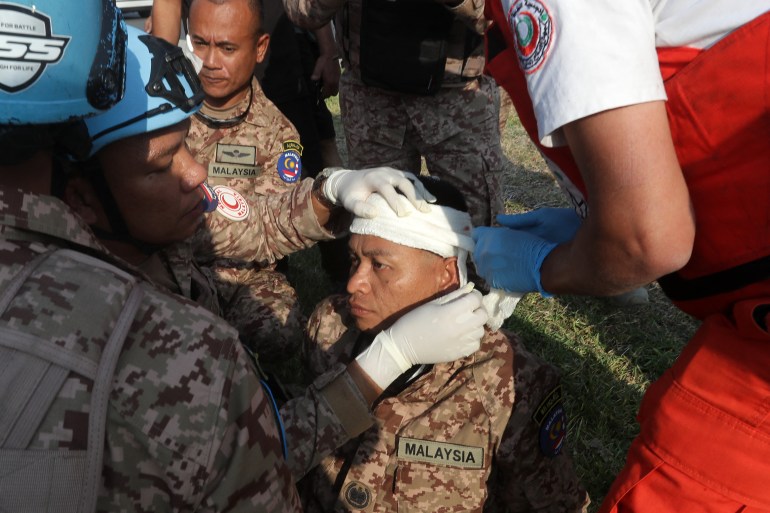 A rescuer and a member of the Malaysian battalion of the United Nations Interim Force In Lebanon (UNIFIL) treat the wound of a fellow soldier, after he was injured at the site of an Israeli airstrike at the northern entrance of the southern Lebanese city of Sidon, on November 7, 2024. - Five UN peacekeepers were wounded in an Israeli air strike in south Lebanon on November 7, the United Nations said, in a raid that also killed three civilians. (Photo by MAHMOUD ZAYYAT / AFP)