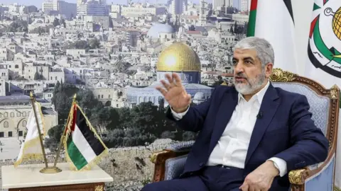 Reuters Khaled Meshaal sits in a chair in Doha beside a large picture of Jerusalem