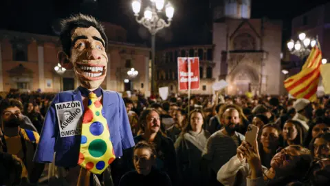 KAI FORSTERLING/EPA-EFE/REX/Shutterstock A person holds a doll depicting Valencia's Regional President Carlos Mazon as thousands of people take part in a protest to call for the resignation of Valencia's regional government due to the management of the floods in Valencia province, in Valencia, Spain, 09 November 2024.