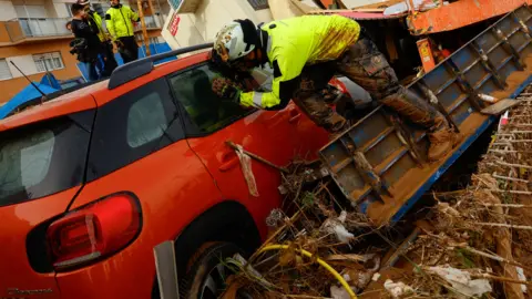 Reuters A firefighter looks inside a car 