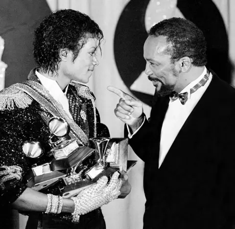 Getty Images Quincy Jones and Michael Jackson at the 1984 Grammy Awards - Jones is pointing affectionately at Jackson, who is holding several Grammys in his arms