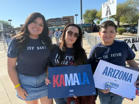 Peria Alcaraz and her mom Monica Alcaraz and her brother holding Harris placards 