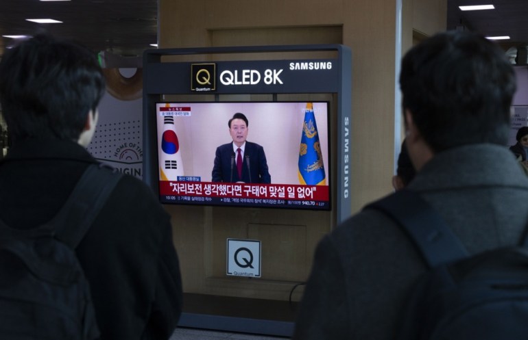 epaselect epa11771693 People watch a television news live broadcast of South Korean President Yoon Suk Yeol addressing the nation, at a station in Seoul, South Korea, 12 December 2024. President Yoon Suk Yeol has been prohibited from leaving the country, according to the Justice Ministry, amid an investigation into his declaration of martial law last week. The opposition Democratic Party intends to resubmit an impeachment motion against Yoon for a vote on 14 December. EPA-EFE/JEON HEON-KYUN