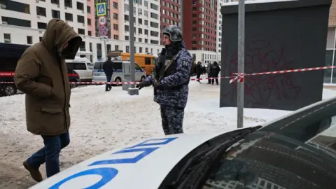 YURI KOCHETKOV/EPA-EFE/REX A Russian policeman dressed in a blue camouflage uniform stands guard near the scene of the killing of a Russian general in Moscow