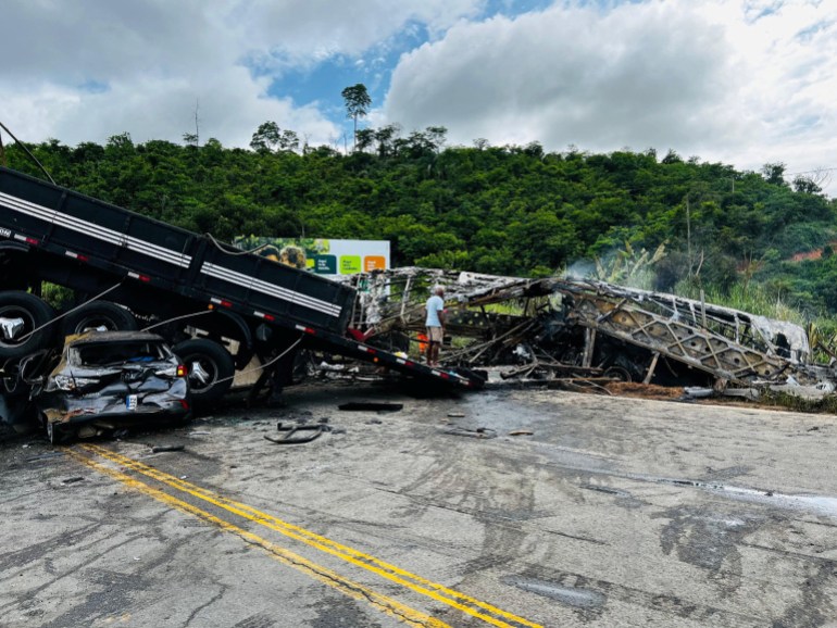 A person inspects the scene of a traffic accident after a packed bus collided with a truck, at the Fernao Dias national highway, near Teofilo Otoni