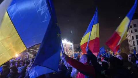 Sarah Rainsford/BBC Romanians fly flags in the centre of Bucharest 