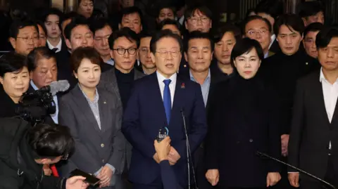 Reuters The leader of a key opposition party, the Democratic Party, stands with several other lawmakers while addressing media after parliament voted down martial law on Wednesday morning