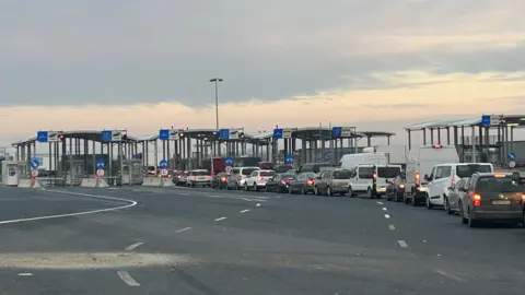 BBC/Nick Thorpe Cars wait at the border between Romania and Hungary