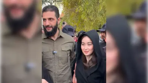 X Ahmed al-Sharaa posing beside a young Syrian woman with her hood up