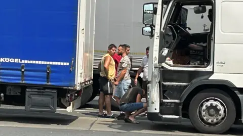 BBC/Nick Thorpe Lorry drivers wait at the border between Hungary and Romania during the summer