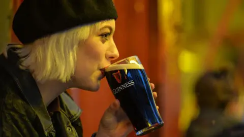 Getty Images Woman drinks pint of Guinness