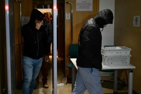 Getty Images Two men wearing their hoods up leave the courtroom