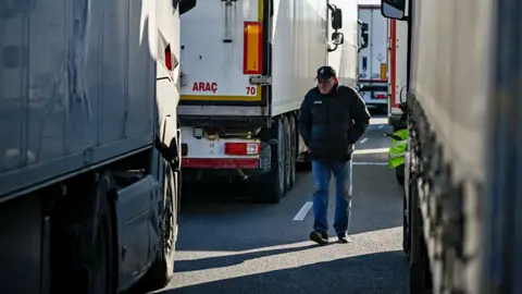 Getty Images A trucker walks between trucks at a border crossing between Bulgaria and Romania