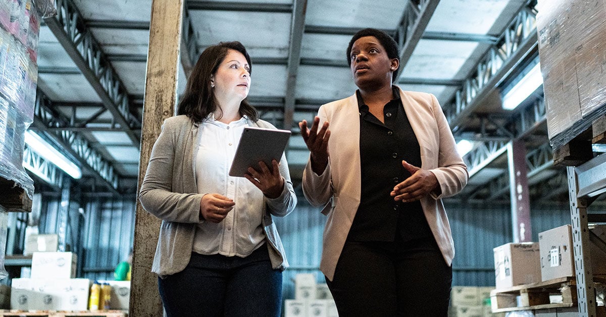 women-walking-talking-in-warehouse-1200x628