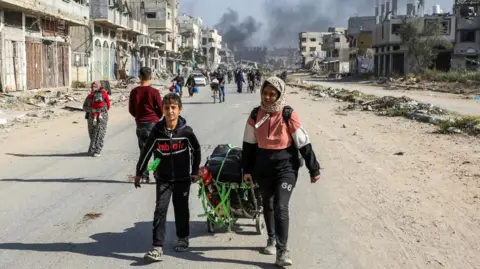 Reuters Displaced Palestinians walk along road in Gaza (file photo)
