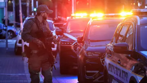 Reuters An Israeli police officer walks at the scene of a suspected attack in Tel Aviv,