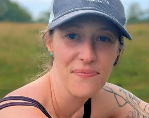 Kelsey Lahr Kelsey Lahr wears a baseball cap in a field near her home in Asheville, North Carolina