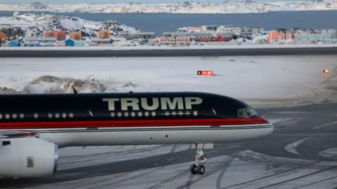 Getty Images An aircraft carrying President-elect Donald Trump's son, Donald Trump Junior, arrives in Nuuk, Greenland on 7 January 2025. Colourful buildings and snow are visible in the background.